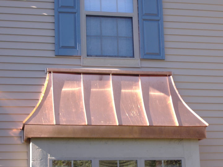 Custom copper bay window hood roof with copper-clad fascia .
