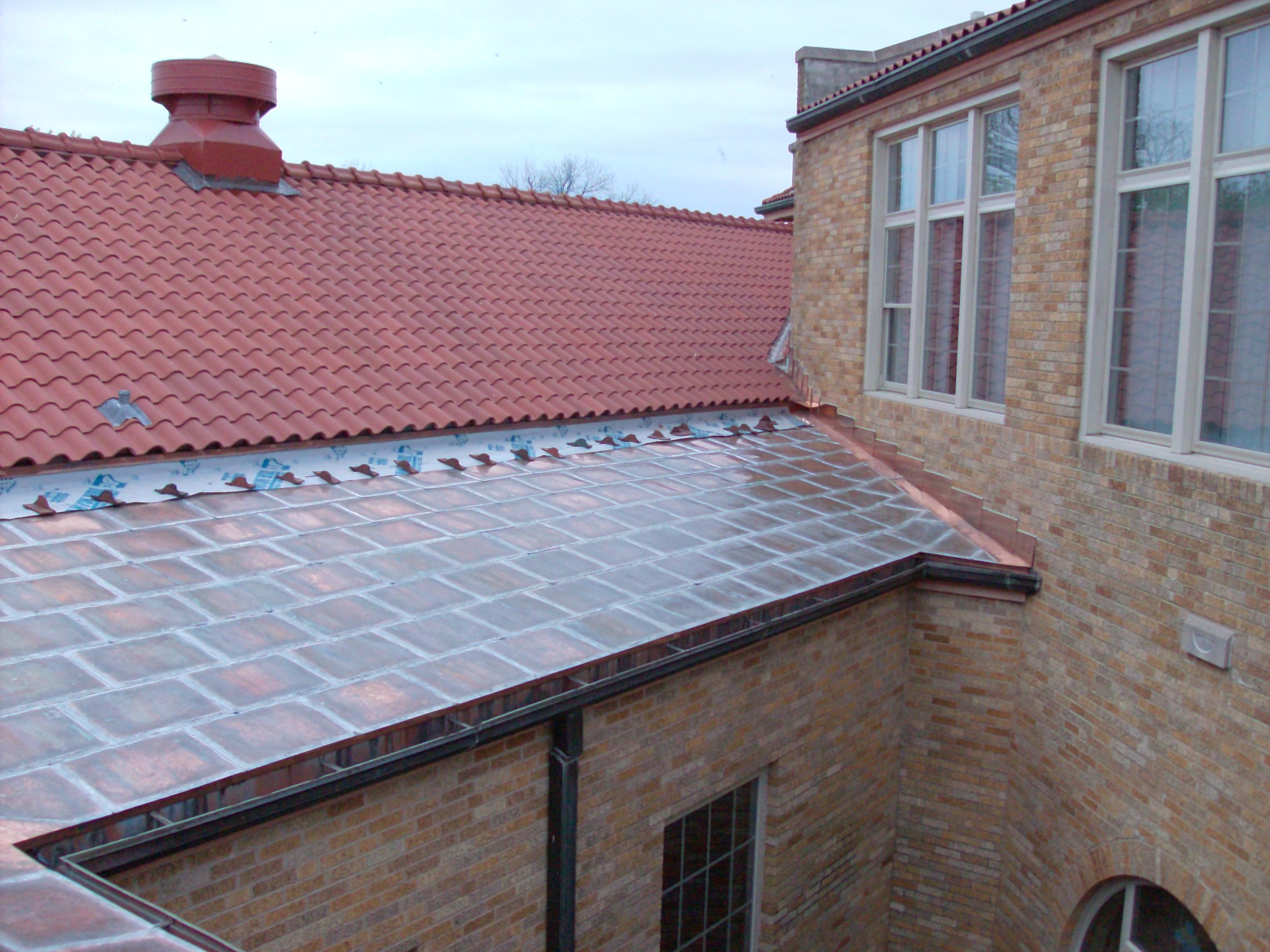 Flat lock copper roof with stepped counter flashing.