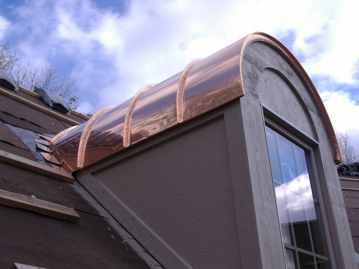 Copper barrel dormer standing seam roof.